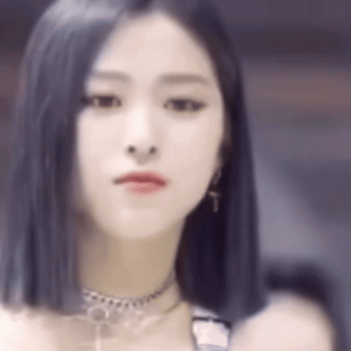 A Close Up Of A Woman 'S Face With A Choker And Earrings . GIF