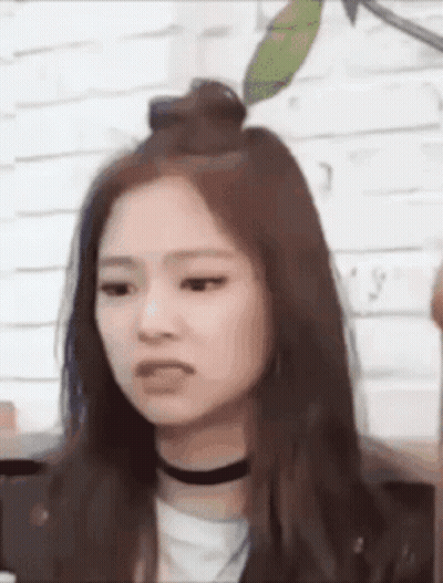 A Close Up Of A Woman 'S Face With A Choker Around Her Neck . GIF
