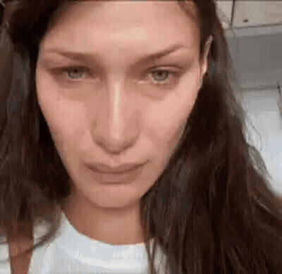 A Close Up Of A Woman 'S Face With A Crying Look On Her Face . GIF