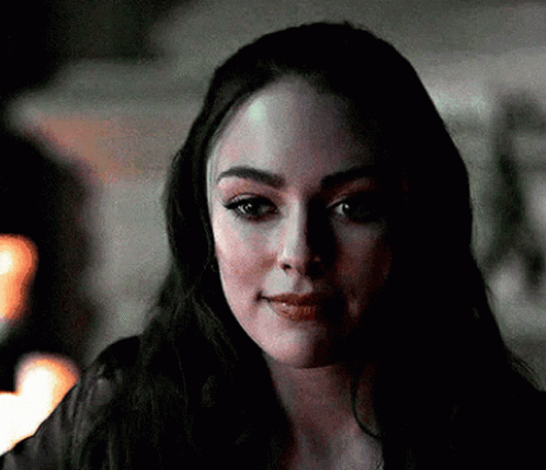 A Close Up Of A Woman 'S Face With A Dark Background . GIF