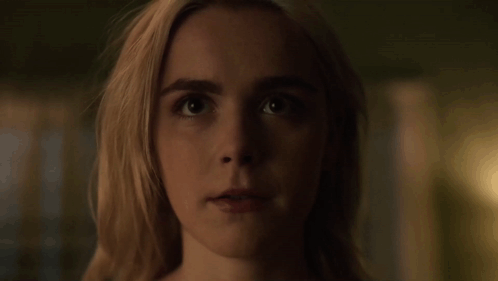 A Close Up Of A Woman 'S Face With A Dark Background . GIF