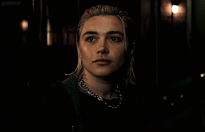 A Close Up Of A Woman 'S Face With A Dark Background And The Word Gatiaxa On The Bottom Right GIF