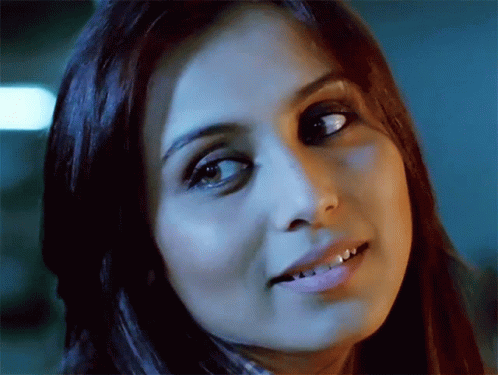 A Close Up Of A Woman 'S Face With A Dark Background GIF