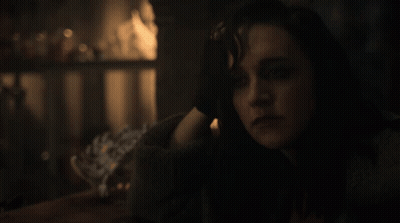 A Close Up Of A Woman 'S Face With A Dark Background GIF