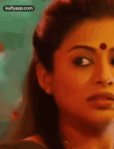 A Close Up Of A Woman 'S Face With A Dot On Her Forehead . GIF