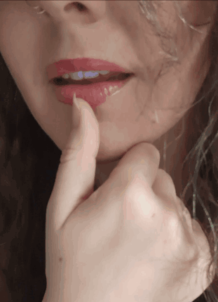 A Close Up Of A Woman 'S Face With A Finger On Her Lips GIF