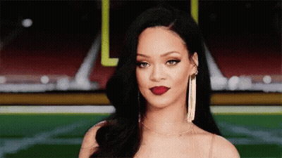 A Close Up Of A Woman 'S Face With A Football Field In The Background . GIF
