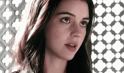 A Close Up Of A Woman 'S Face With A Geometric Pattern Behind Her GIF