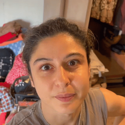 A Close Up Of A Woman 'S Face With A Gray Shirt On GIF
