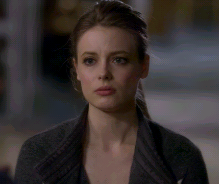 A Close Up Of A Woman 'S Face With A Gray Sweater On GIF
