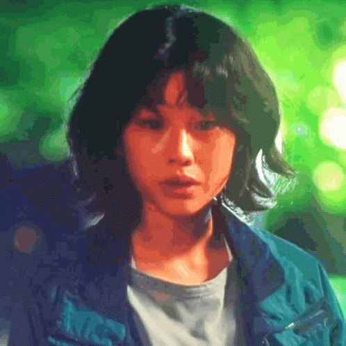 A Close Up Of A Woman 'S Face With A Green Background . GIF