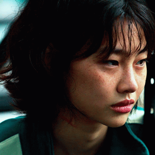 A Close Up Of A Woman 'S Face With A Green Jacket On GIF