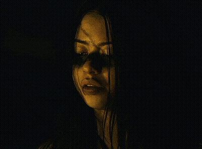 A Close Up Of A Woman 'S Face With A Hand Covering Her Mouth GIF