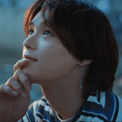 A Close Up Of A Woman 'S Face With A Hand On Her Chin GIF