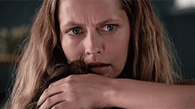 A Close Up Of A Woman 'S Face With A Hand On Her Face GIF