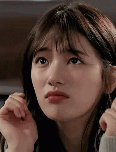 A Close Up Of A Woman 'S Face With A Hand On Her Face . GIF