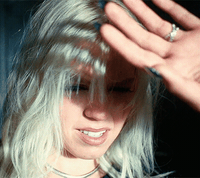 A Close Up Of A Woman 'S Face With A Hand On Her Forehead GIF