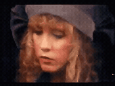 A Close Up Of A Woman 'S Face With A Hat On . GIF