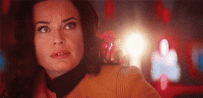 A Close Up Of A Woman 'S Face With A Light Coming Out Of Her Mouth . GIF