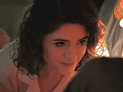 A Close Up Of A Woman 'S Face With A Light Shining On Her Face . GIF