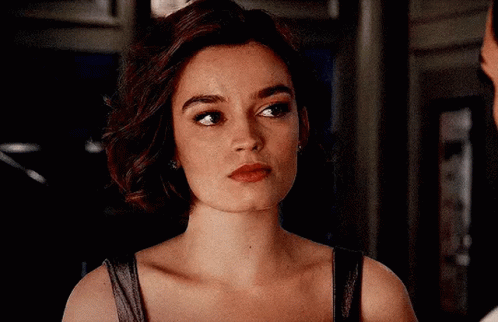 A Close Up Of A Woman 'S Face With A Man Behind Her . GIF