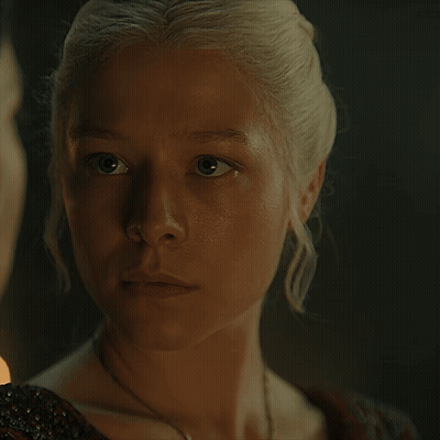 A Close Up Of A Woman 'S Face With A Man In The Background GIF