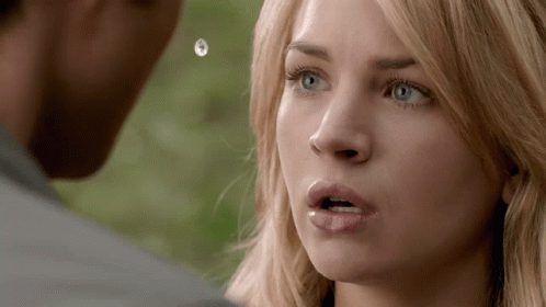 A Close Up Of A Woman 'S Face With A Man 'S Face In The Background GIF