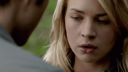 A Close Up Of A Woman 'S Face With A Man 'S Face In The Background GIF