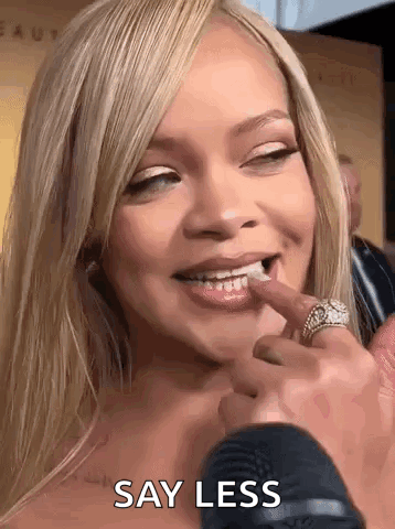 A Close Up Of A Woman 'S Face With A Microphone And The Words `` Say Less '' Written On It . GIF