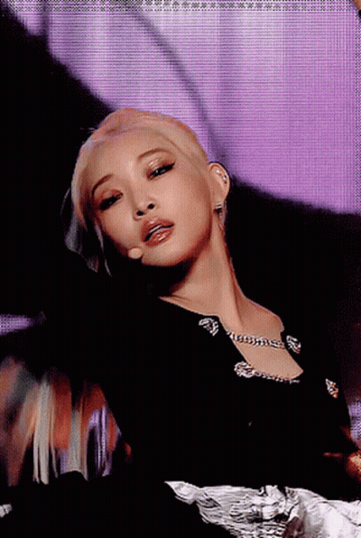 A Close Up Of A Woman 'S Face With A Microphone In Front Of Her GIF