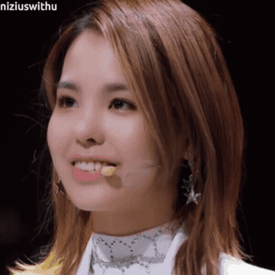 A Close Up Of A Woman 'S Face With A Microphone Sticking Out Of Her Mouth . GIF