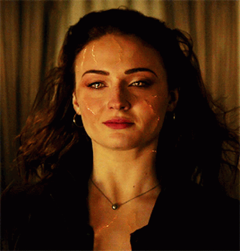 A Close Up Of A Woman 'S Face With A Necklace And Earrings GIF
