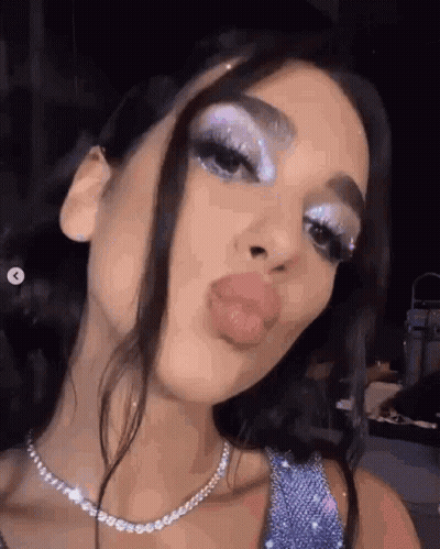 A Close Up Of A Woman 'S Face With A Necklace And Makeup On . GIF