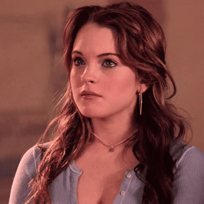 A Close Up Of A Woman 'S Face With A Necklace Around Her Neck GIF