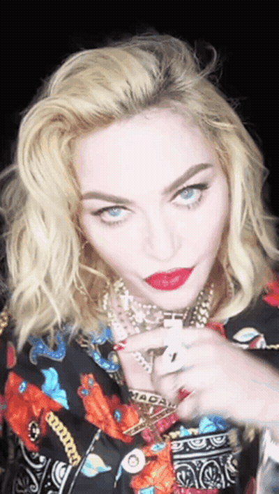 A Close Up Of A Woman 'S Face With A Necklace That Says Macau On It GIF