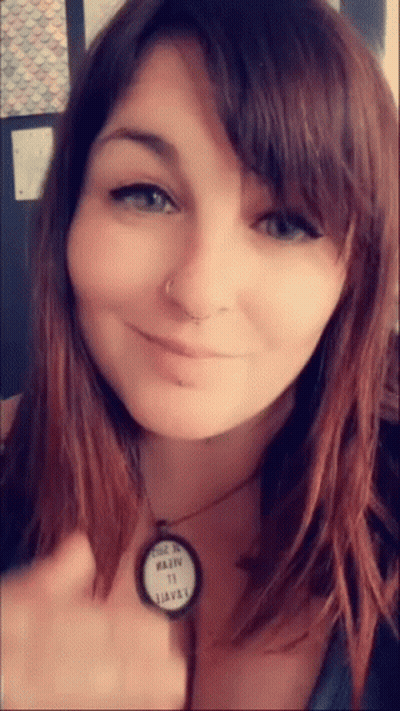 A Close Up Of A Woman 'S Face With A Necklace That Says ' Made In Usa ' On It GIF