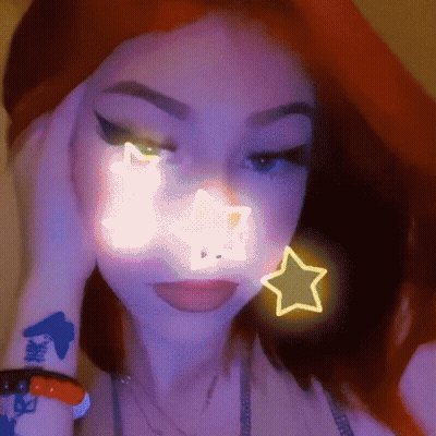 A Close Up Of A Woman 'S Face With A Neon Star On It . GIF