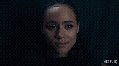 A Close Up Of A Woman 'S Face With A Netflix Logo In The Background GIF