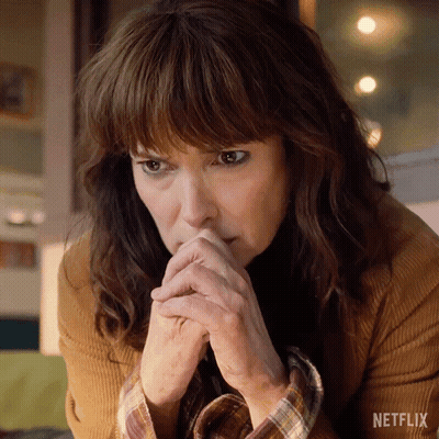 A Close Up Of A Woman 'S Face With A Netflix Logo In The Background GIF