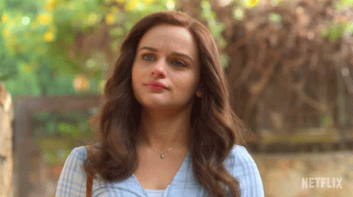 A Close Up Of A Woman 'S Face With A Netflix Logo In The Background GIF