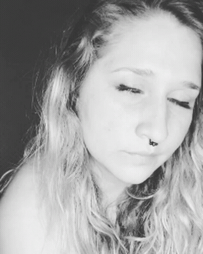 A Close Up Of A Woman 'S Face With A Nose Ring GIF