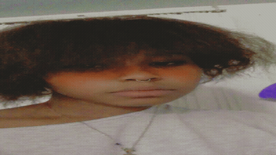 A Close Up Of A Woman 'S Face With A Nose Ring And A Necklace GIF