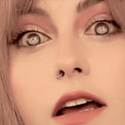 A Close Up Of A Woman 'S Face With A Nose Ring And A Surprised Look On Her Face . GIF