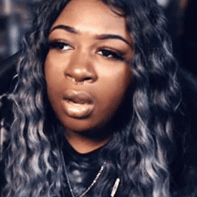 A Close Up Of A Woman 'S Face With A Nose Ring And Gray Hair . GIF