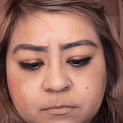 A Close Up Of A Woman 'S Face With A Nose Ring On Her Nose . GIF