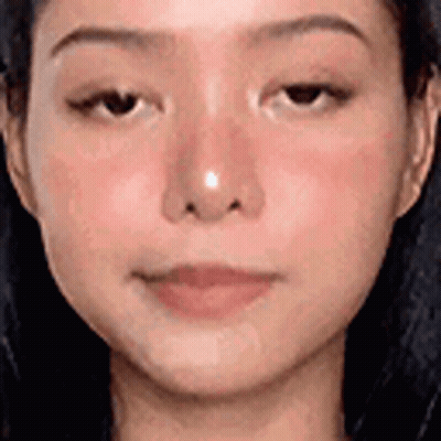 A Close Up Of A Woman 'S Face With A Nose Ring On It . GIF