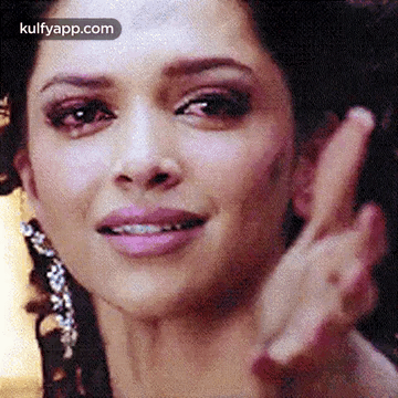 A Close Up Of A Woman 'S Face With A Peace Sign . GIF