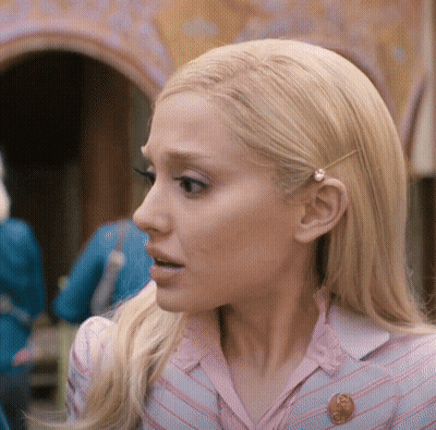 A Close Up Of A Woman 'S Face With A Penny Pin In Her Hair GIF