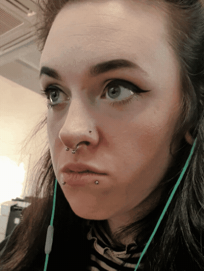 A Close Up Of A Woman 'S Face With A Piercing In Her Nose GIF