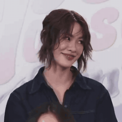 A Close Up Of A Woman 'S Face With A Pink Background GIF